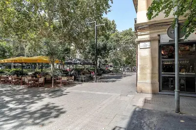 a street with tables and chairs outside of a building at Canela Homes BARCELONA ATIC in Barcelona