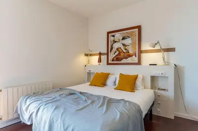 a white bedroom with a bed with yellow pillows at Canela Homes BARCELONA ATIC in Barcelona