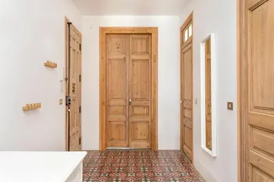 a hallway with a wooden door and a tile floor at Canela Homes BARCELONA CONCEPCIÓ in Barcelona