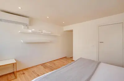 a white bedroom with a bed and a closet at Urban Flats Park Guell in Barcelona