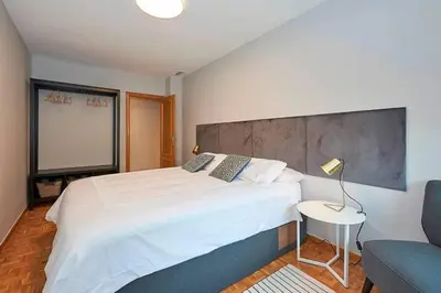 a bedroom with a large white bed and a couch at Canela Homes BARCELONA TETUAN in Barcelona