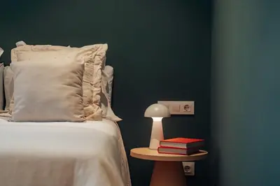 a bedroom with a bed and a table with books at Casa Seda in Barcelona