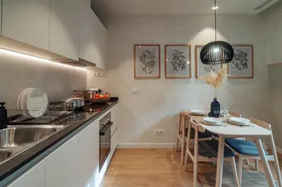 a kitchen with a table with chairs and a sink at Casa Seda in Barcelona