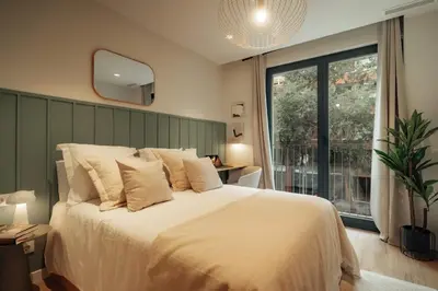 a bedroom with a large bed and a large window at Casa Tila in Barcelona