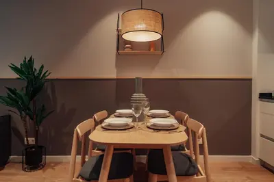 a dining room table with chairs and a lamp at Casa Tila in Barcelona