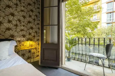 a bedroom with a balcony with a bed and a window at Dana - Enjoy Apartments Rocafort in Barcelona