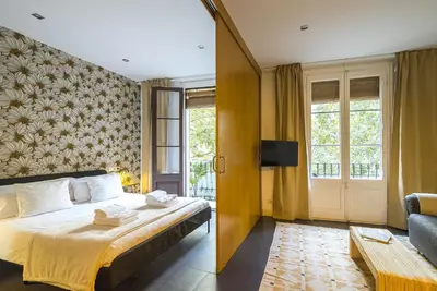 a hotel room with a bed and a couch at Dana - Enjoy Apartments Rocafort in Barcelona