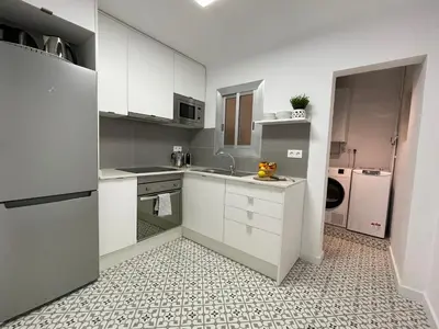 a white kitchen with a sink and a refrigerator at 15 min en metro a Sagrada Familia in Sant Adria de Besos