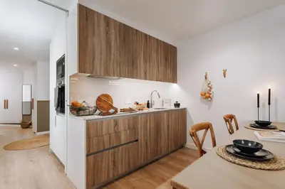 a kitchen and living room with a large wooden table at Olivo - 1 bedroom and terrace in Eixample Esquerra in Barcelona