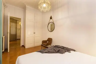 a bedroom with a bed and a chair and a mirror at Canela Homes BARCELONA INDÚSTRIA in Barcelona