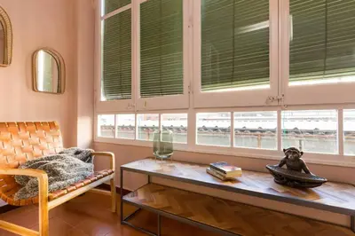 a living room with a table and some windows at Canela Homes BARCELONA INDÚSTRIA in Barcelona