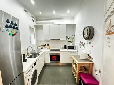 a kitchen with white cabinets and a stainless steel refrigerator at Isabela rooms in Barcelona