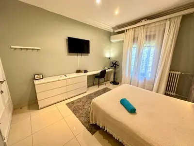 a bedroom with two beds and a desk with a television at Isabela rooms in Barcelona