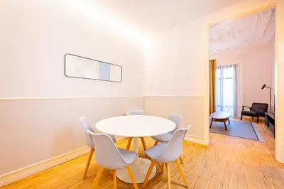 a dining room with a white table and chairs at Sweett - La Gran Via in Barcelona