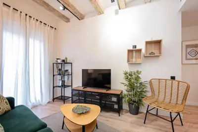 a living room with a couch and a tv and a table at Sweett - Urgell Eixample in Barcelona