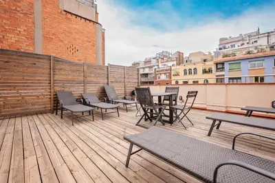 a deck with chairs and tables on a building at Sweett - Urgell Eixample in Barcelona