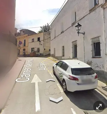 a white car parked in a street next to a building at Vista Alegre Casa Rest House in Vallromanas