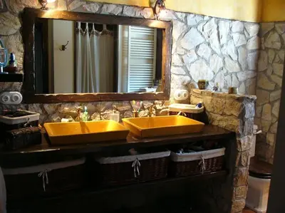 a bathroom with two yellow sinks and a mirror at L'AMAGATALL DEL MONTNEGRE in Villalba Saserra