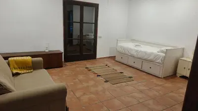 a living room with a bed and a tiled floor at L'AMAGATALL DEL MONTNEGRE in Villalba Saserra