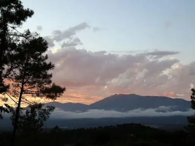 a sunset over a mountain range with clouds in the sky at L'AMAGATALL DEL MONTNEGRE in Villalba Saserra