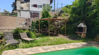a backyard with a picnic table and chairs next to a pool at L'AMAGATALL DEL MONTNEGRE in Villalba Saserra