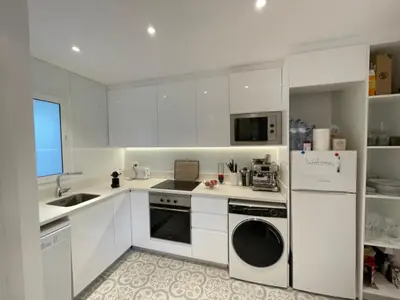 a kitchen with white cabinets and a sink and a dishwasher at Paseo de Gracia Residences in Barcelona
