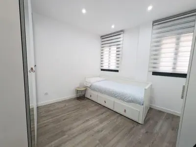 a bedroom with a bed and two windows and a mirror at New flat in the centre, 10 min from BCN Airport in Cornellà de Llobregat