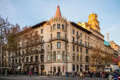 a large building on a busy city street with people at Victoria City Center Barcelona in Barcelona