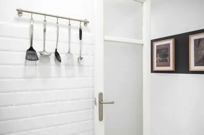 a bathroom with a white shower with utensils on a rack at SAGRADA FAMILIA SUN Nos preocupa su seguridad in Barcelona