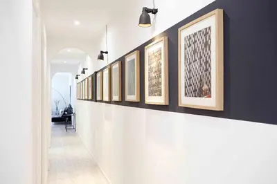 a hallway with a row of framed pictures on a wall at SAGRADA FAMILIA SUN Nos preocupa su seguridad in Barcelona