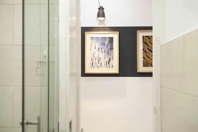 a bathroom with two framed paintings on the wall at SAGRADA FAMILIA SUN Nos preocupa su seguridad in Barcelona