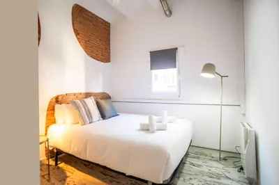 a white bedroom with a white bed and a window at Fantástico piso en Barcelona in Barcelona