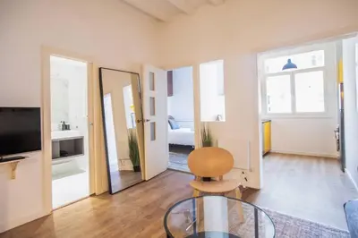 a living room with a glass table and a chair at Fantástico piso en Barcelona in Barcelona