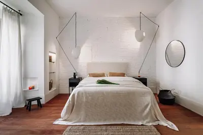 a white bedroom with a large bed and a brick wall at Zuheros - 2 bedrooms in Eixample Dreta in Barcelona