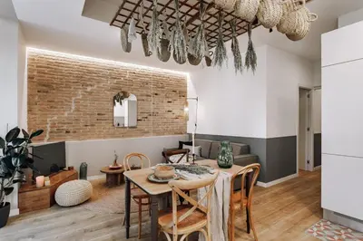 a living room with a television and a brick wall at Aroche - 2 bedrooms in Sant Antoni in Barcelona