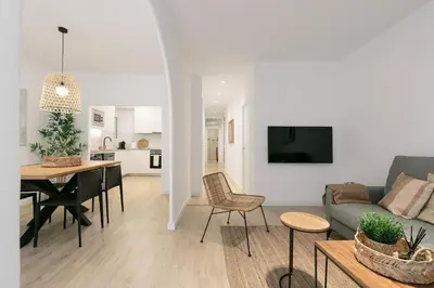 a living room and kitchen with a couch and a table at Cathedral Ramblas Apartment in Barcelona