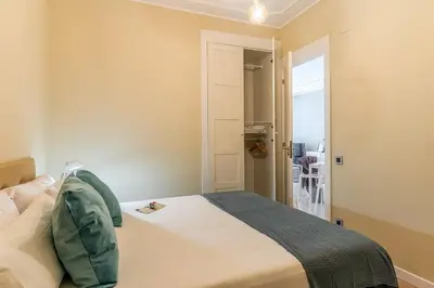 a bedroom with a bed with a green pillow on it at Canela Homes BARCELONA SANT PAU in Barcelona