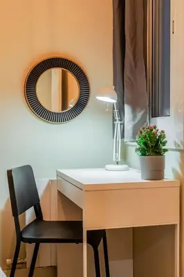 a desk with a chair and a mirror on a wall at Canela Homes BARCELONA SANT PAU in Barcelona
