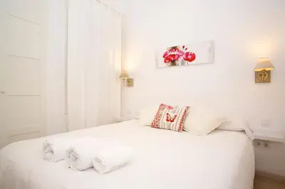 a white bedroom with a white bed with white sheets at Gracia Travesera 2 Bedrooms Renovated Apartment in Barcelona
