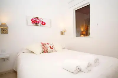 a white bed in a white room with a window at Gracia Travesera 2 Bedrooms Renovated Apartment in Barcelona