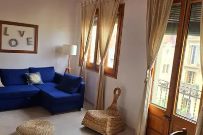 a living room with a blue couch and a window at Gracia Travesera 2 Bedrooms Renovated Apartment in Barcelona
