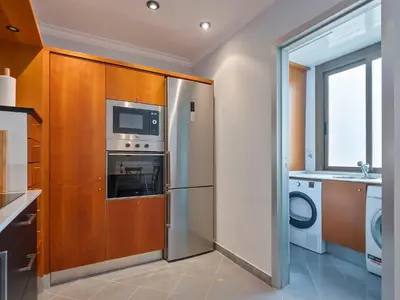 a kitchen with a refrigerator and a washer and dryer at Habitas Stay Barcelona in Barcelona
