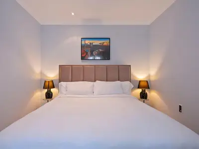 a bedroom with a large white bed with two lamps at Habitas Stay Barcelona in Barcelona