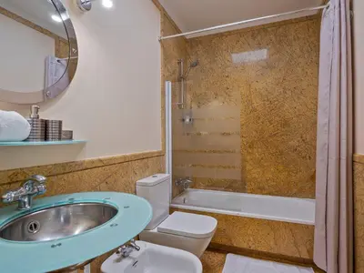 a bathroom with a sink and a toilet and a tub at Habitas Stay Barcelona in Barcelona
