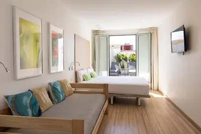 a hotel room with two beds and a couch at SmartRoom Barcelona in Barcelona