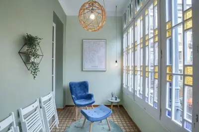 a hallway with a blue chair and a chandelier at Passeig Sant Joan in Barcelona