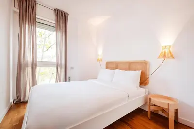 a white bed in a room with a window at Sweett - Nova Icaria Beach in Barcelona