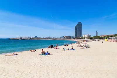 a group of people laying on a beach at Sweett - Nova Icaria Beach in Barcelona