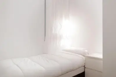 a white bedroom with a bed and a window at Canela Homes BARCELONA AUSIAS MARC in Barcelona