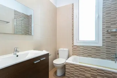 a bathroom with a toilet and a tub and a sink at Canela Homes BARCELONA VALÈNCIA in Barcelona